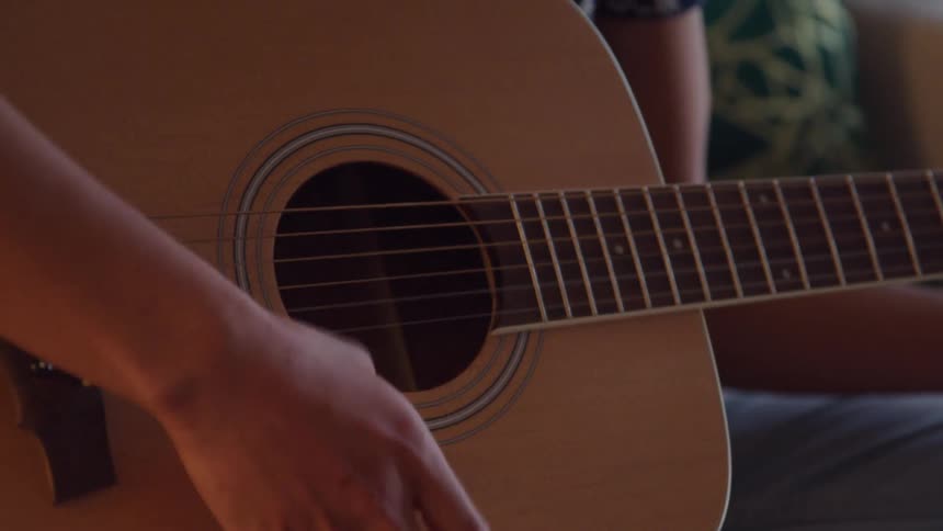 Closeup of a persons hand playing guitar