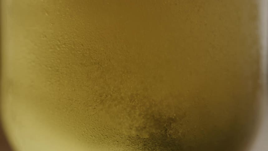 Glass cup being filled with cold beer