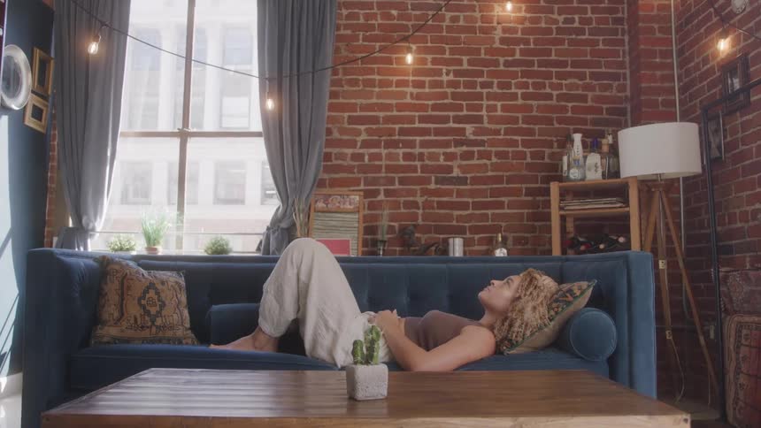 A woman is resting on her couch