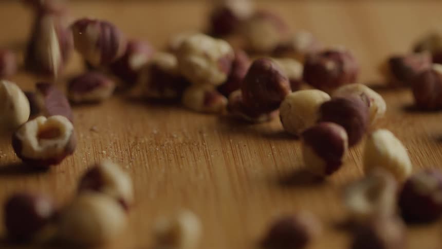 Almonds falling onto a wooden surface