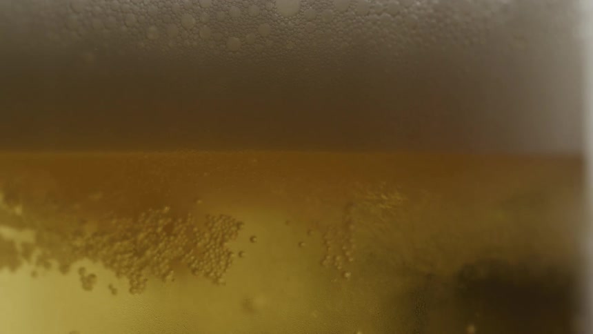 Close up foamy beer froth rising to the top