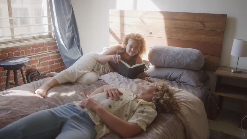 Couple lying on a bed during the day
