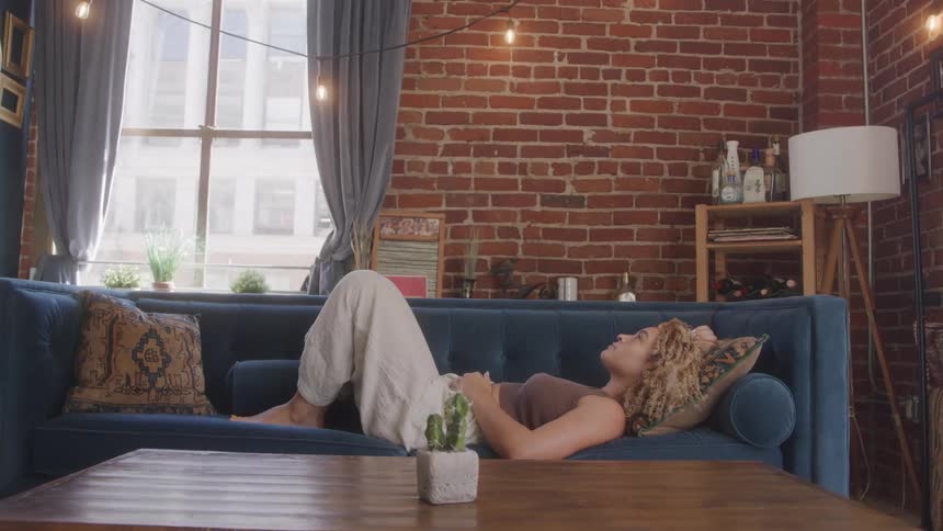 Woman with curly hair lying on a sofa