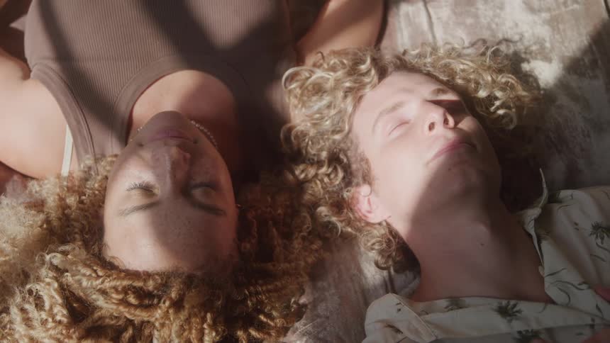 Curlyhaired blond boys with their eyes closed enjoying the sun