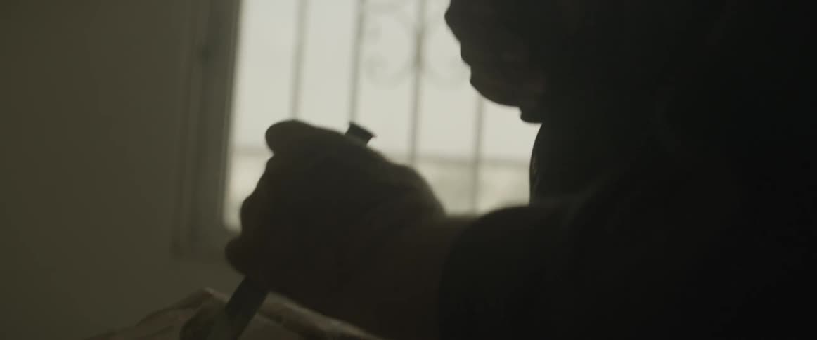 A man chips away at a chunk of wood