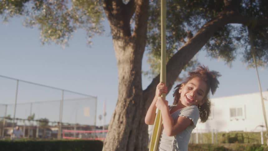 Two girls are swinging from the tree