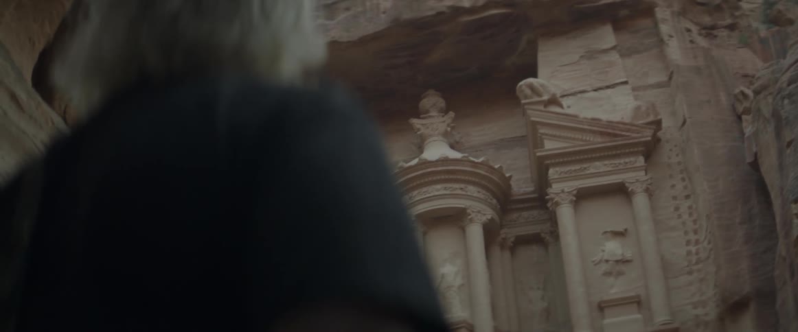 A man looks over to some carvings in stone