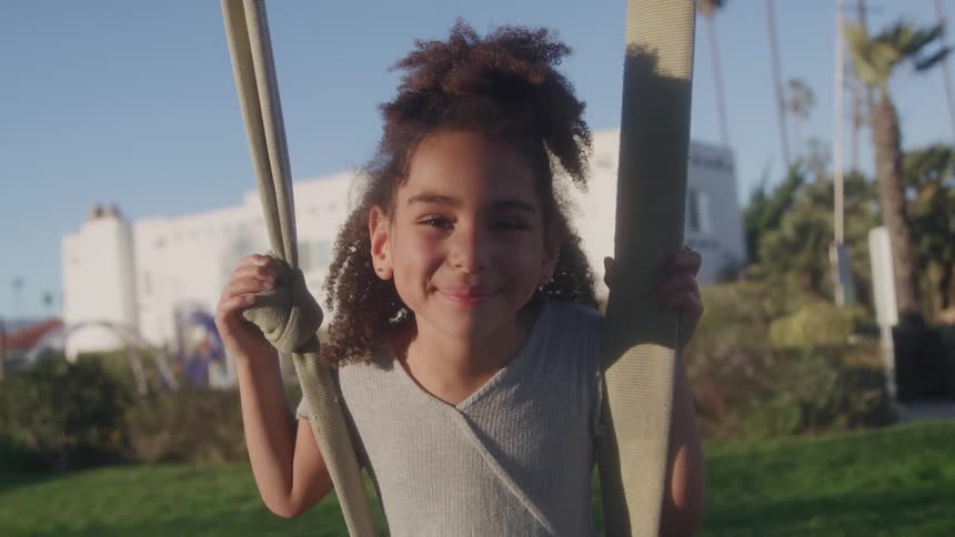 A girl looks happy sitting on a swing