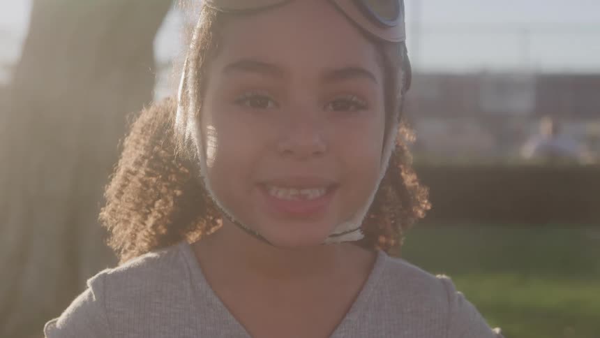 Close up portrait of a girl smiling while standing outdoors in a city during daytime