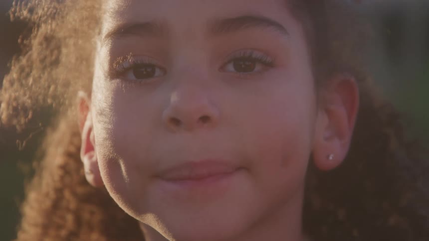 The girl is smiling and blinking