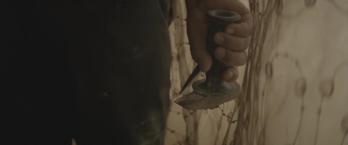 A man holds a hammer and chisel