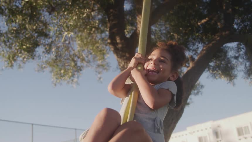 The girl swings on the tree and is having fun