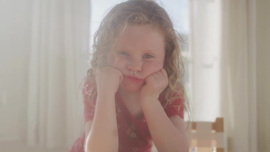 The girl looks sad and is leaning on her hands