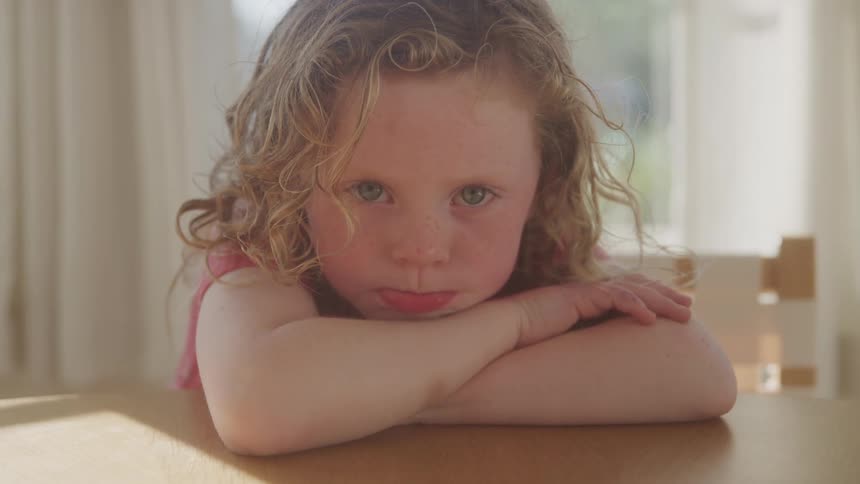 Girl with arms crossed and head resting on the table