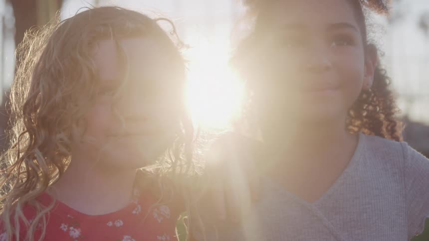Two little girls in a backyard at sunset