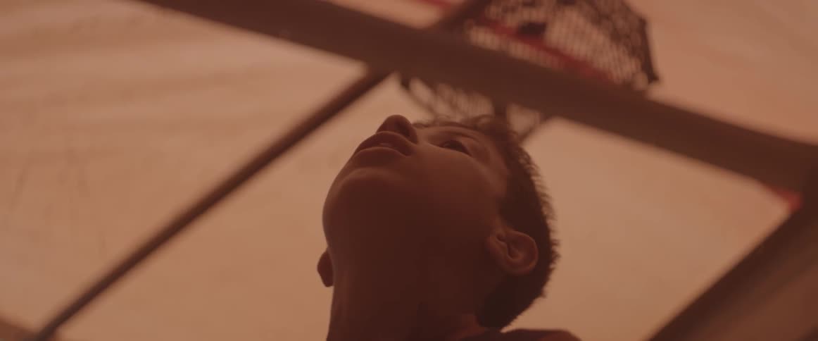 A boy is looking up at the ceiling of the shelter he is in
