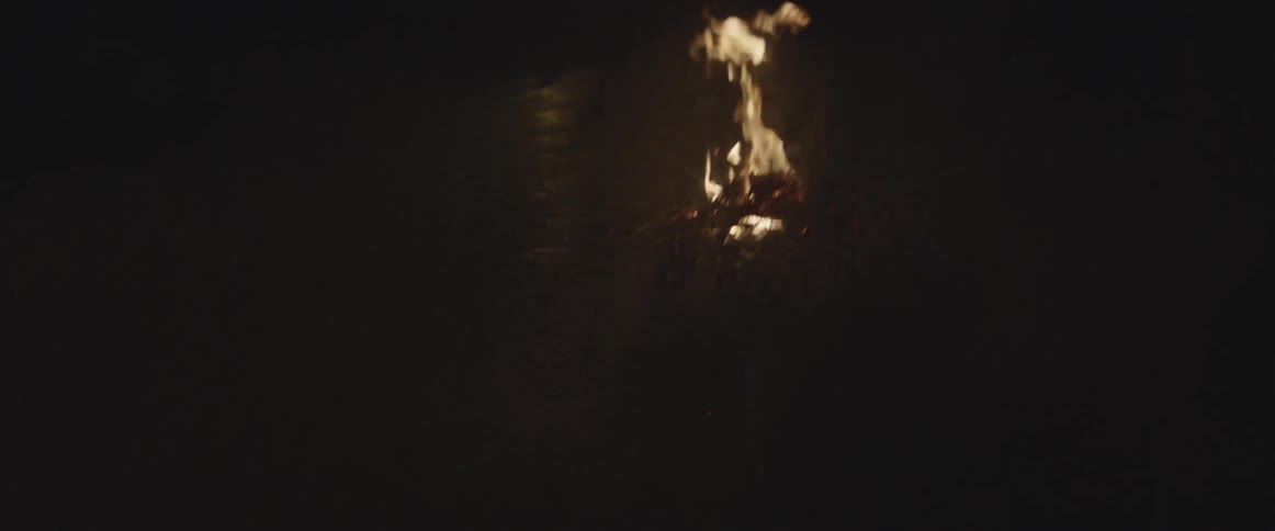 A camp fire burns at night