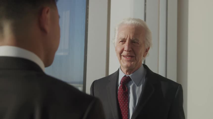Boss smiles while talking with employee in office
