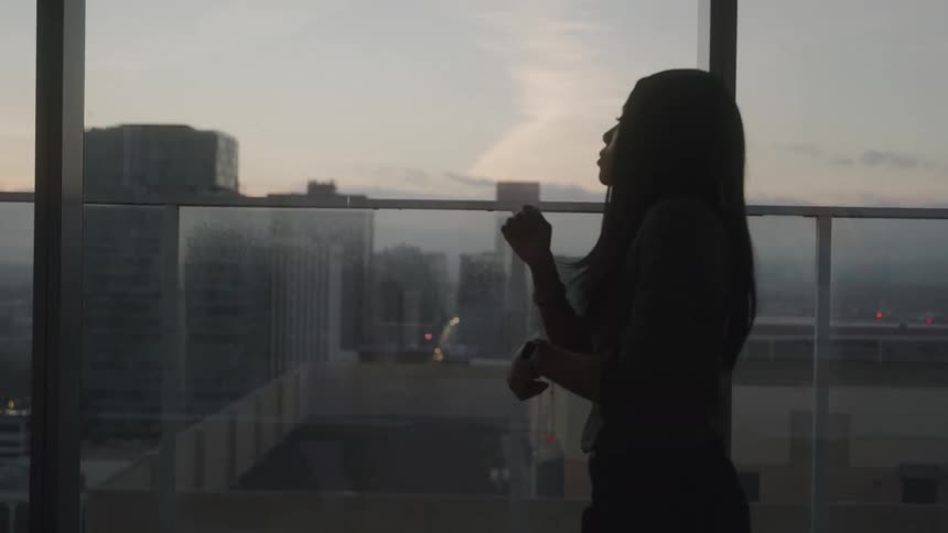 Silhouette of a woman walking into an office room