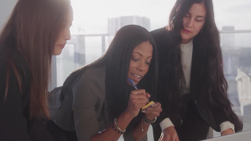 Three women discuss something in the office