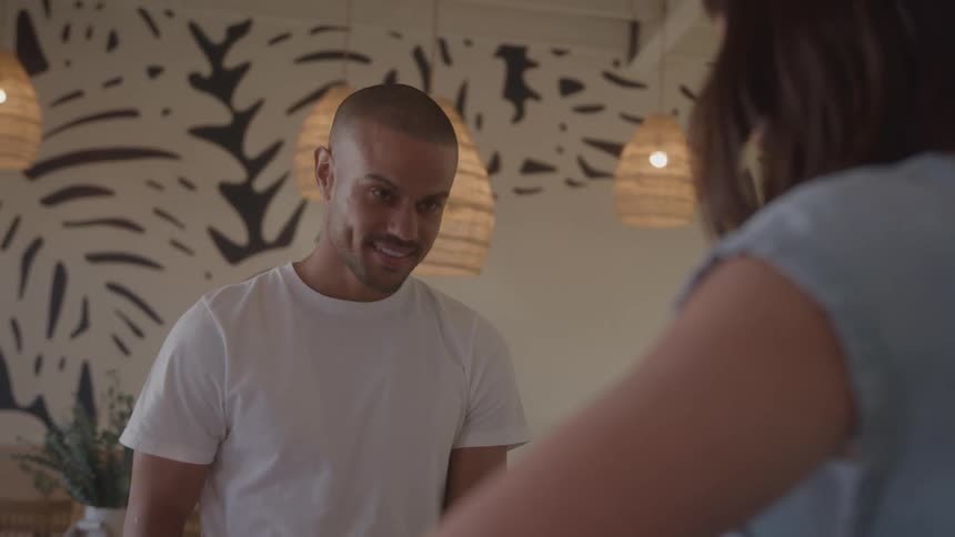 Man smiling while listening to the woman across from him talk
