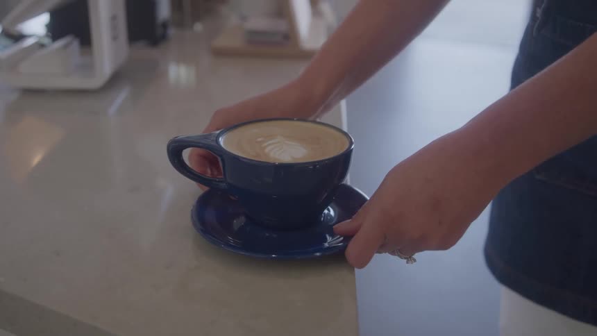Girl takes a cup of cappuccino