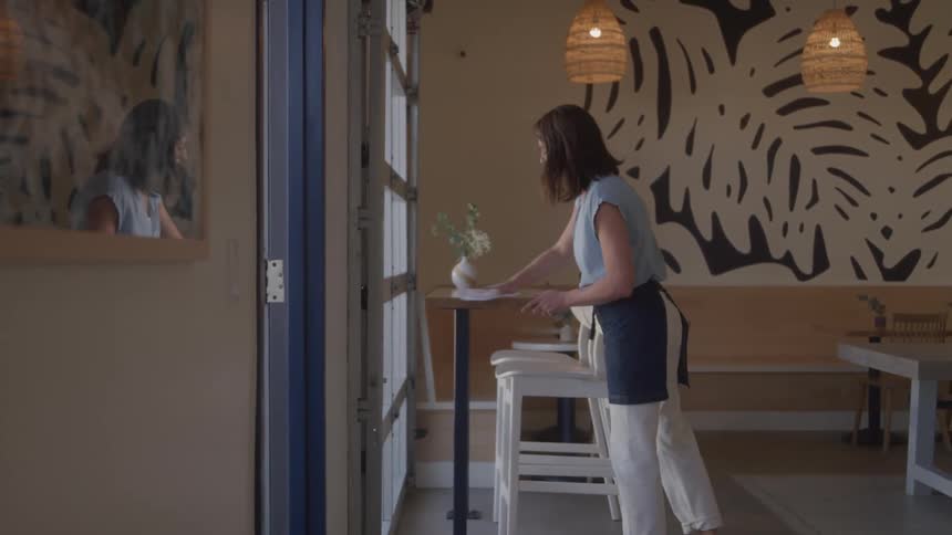 Woman cleaning a table in a coffee shop