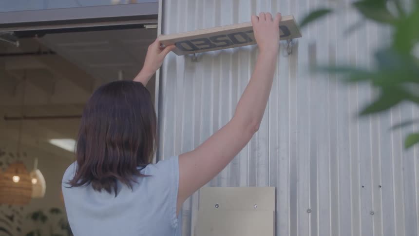 Woman changing a business sign to open