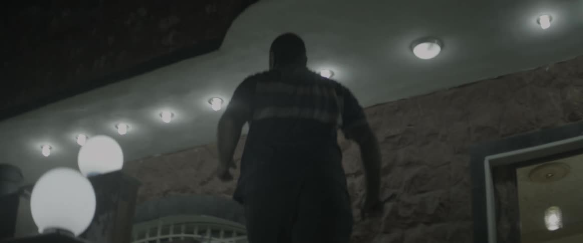 A man rushes up some steps toward a building at night