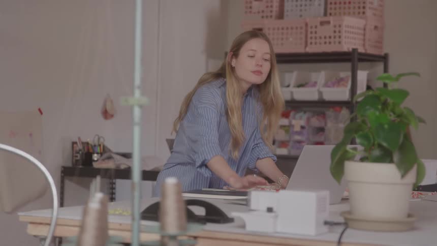 A woman working at a desk in a fashion design studio