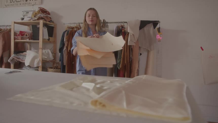 Girl arranging fabrics in her workshop