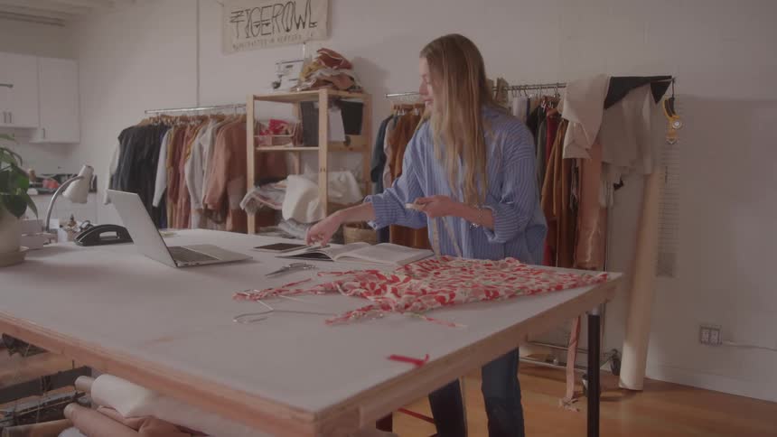 Woman working on fashion design in a studio workspace
