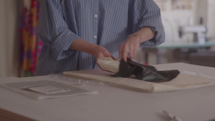 Pair of womans hands packing a product