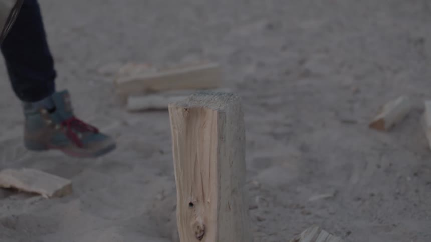 Man cuts a wood log with an axe