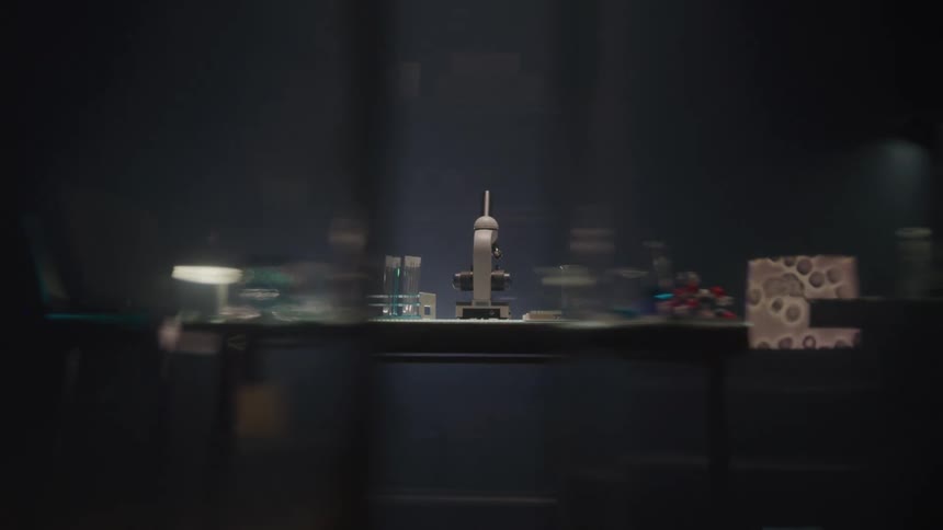 Science laboratory with microscope and equipment in dim lighting