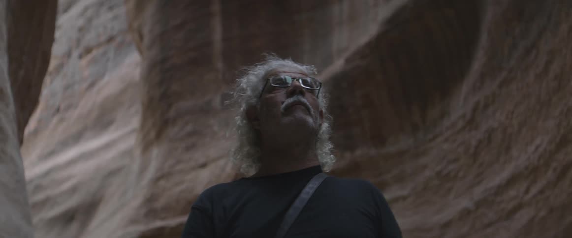 A man looks around to the sky in a cavern