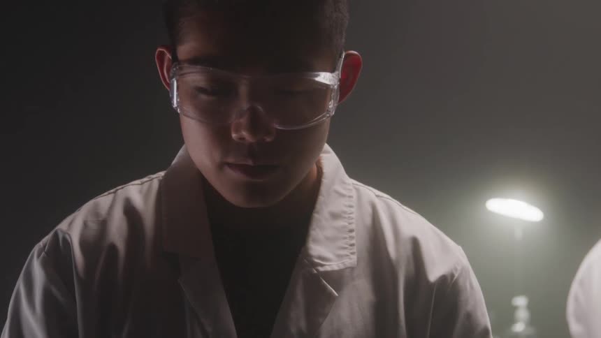 The scientist is looking around in the dark room