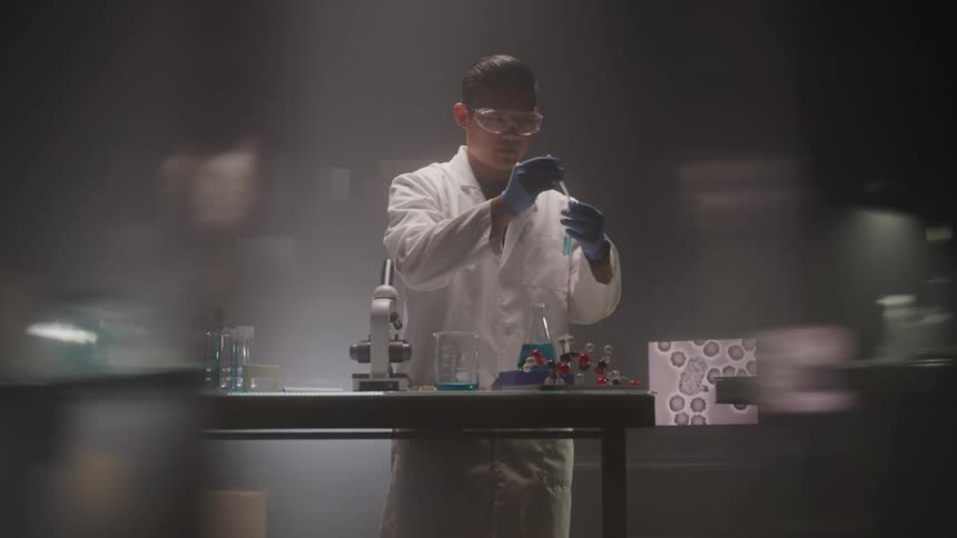 Man in white coat and glasses working in a laboratory