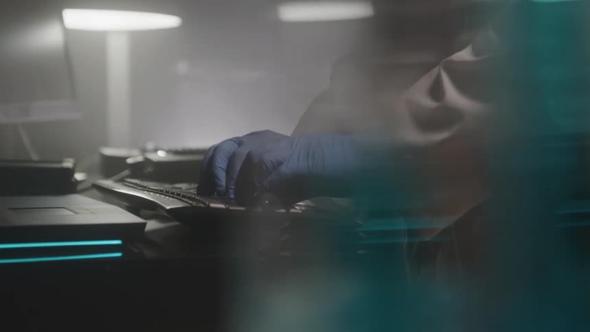 Close up of a scientist typing on a computer keyboard on a table in the lab