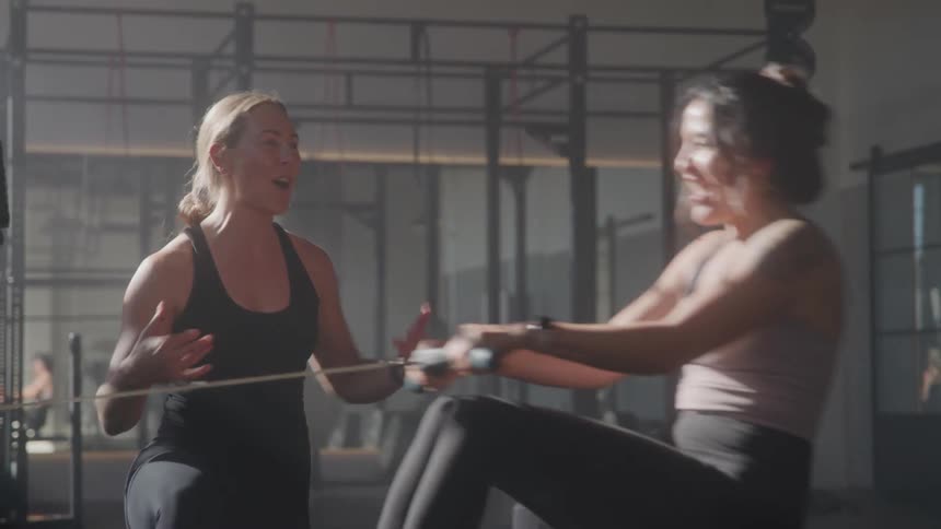 Woman motivating another woman in an aerobic exercise of pulling a rope