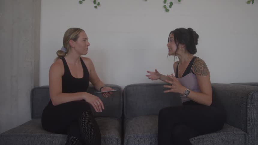Two women sitting on the couch and having a conversation