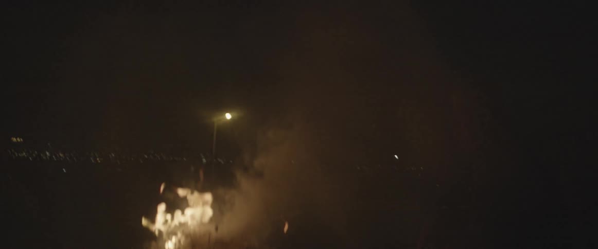 A fire burns near some street lights