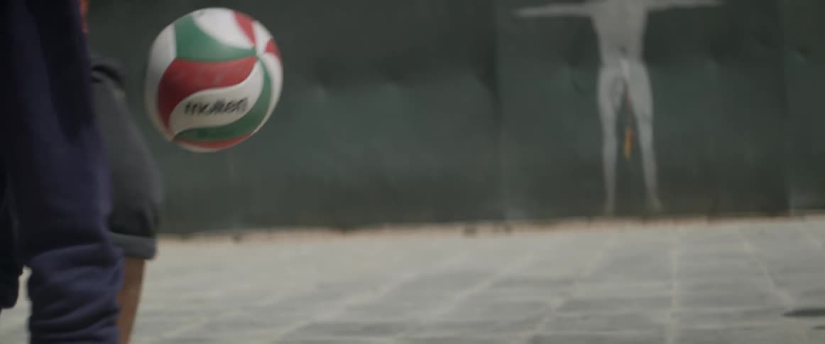 Barefoot children kick a soccer ball