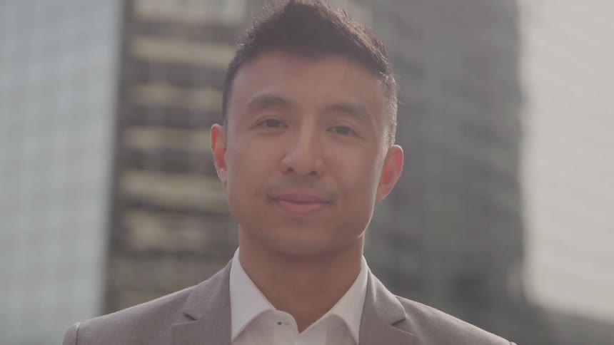 Close up portrait of a young businessman standing outdoors in a metropolitan city during daytime