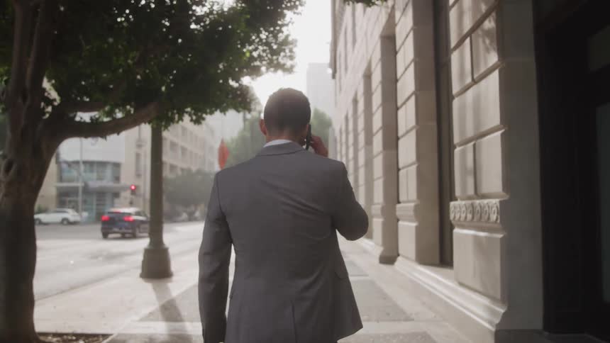 Man talking on the phone with his back turned walking in the city
