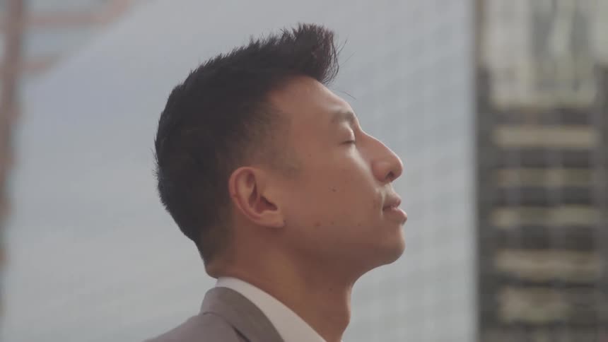 The man is looking up at the buildings