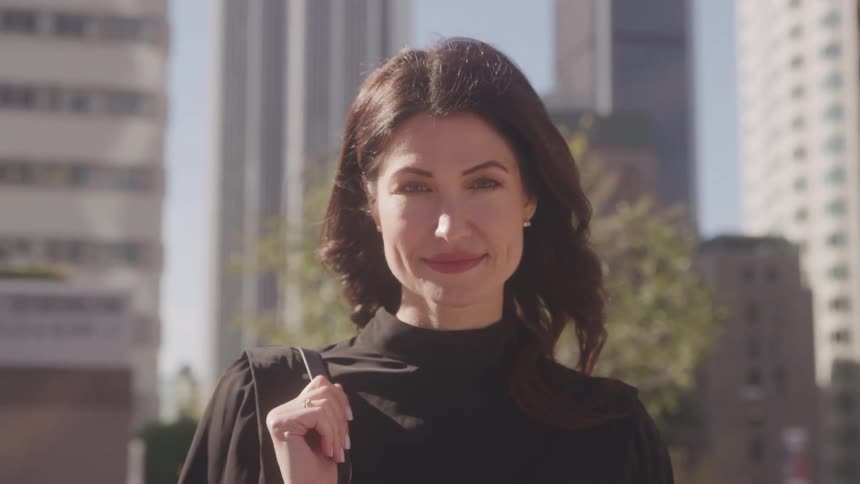 Woman smiles at camera in urban setting