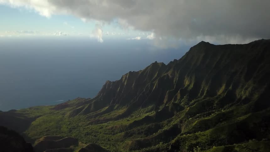 A mountain ridge is covered with trees and grass