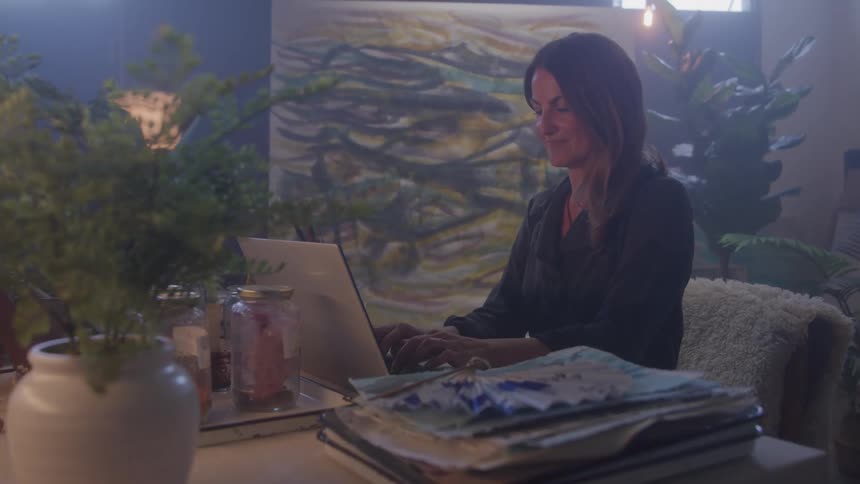 Woman works on a laptop in an artistic environment