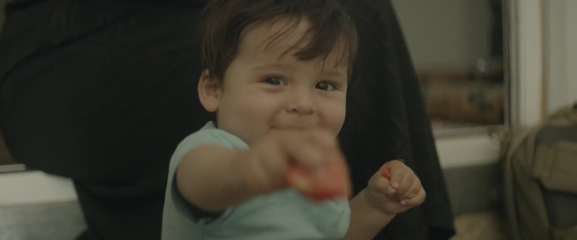 A baby holds a piece of food